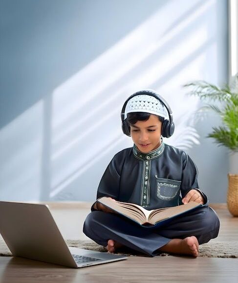 A-boy-is-sitting-on-the-floor-with-headphones-on-his-head-and-learn-online-quran-_-Premium-AI-generated-image-1.jpg